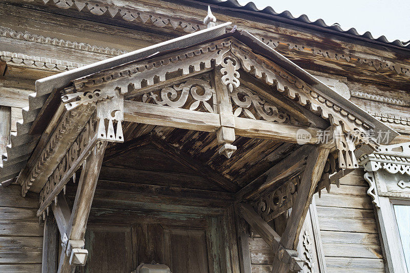 前门上方古老的木质顶篷，带有装饰元素