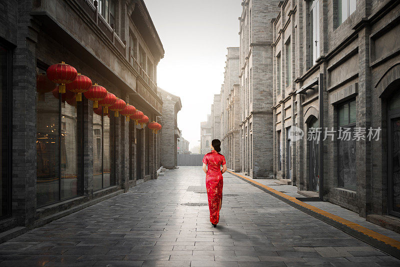 中国北京胡同里穿着传统中国服装的亚洲年轻女子。