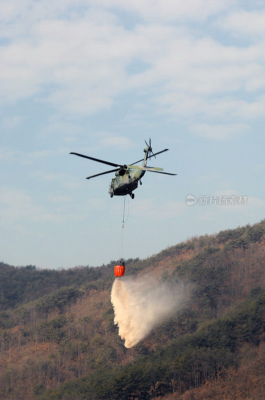 一架军用直升机喷水灭火。