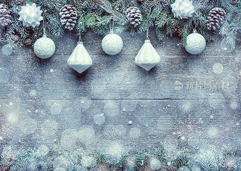 下雪的圣诞节背景，杉树枝与松果和圣诞装饰在木制的背景，节日横幅与拷贝空间
