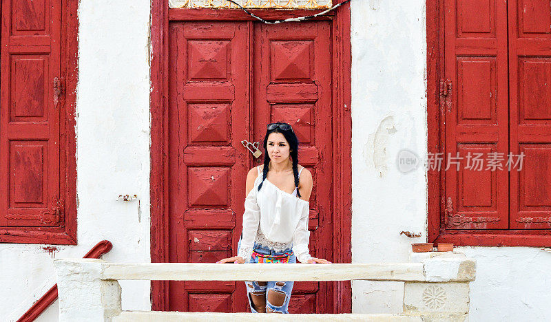 美丽的年轻女子，典型的希腊建筑-米科诺斯