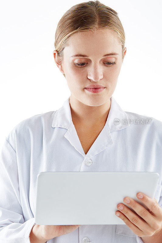 年轻漂亮的金发女人拿着数码平板电脑看起来很严肃