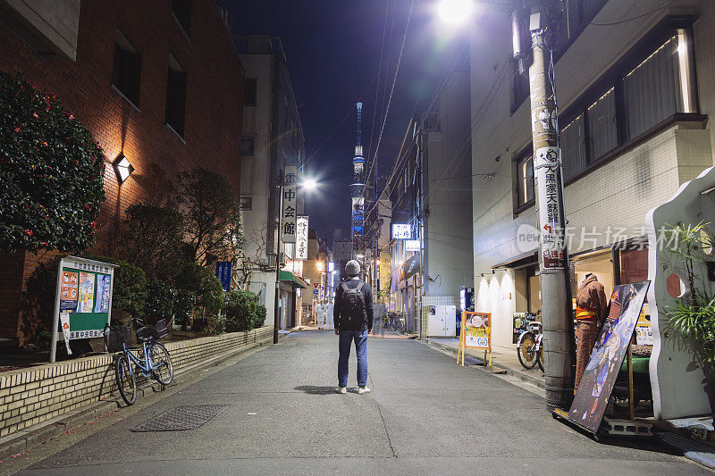 一名游客站在浅草的夜间街道上