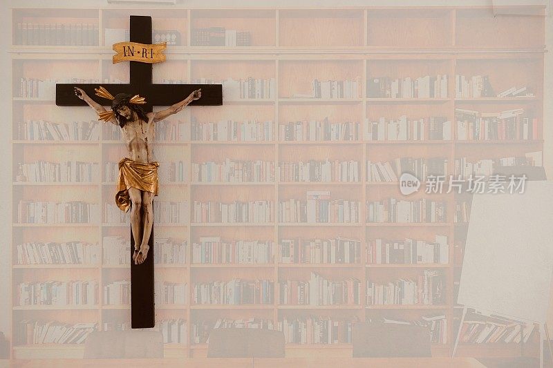 钉十字架在满满的书架上