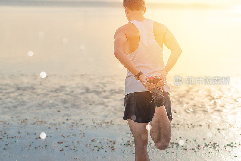 年轻的亚洲男子在日落海滩做瑜伽运动