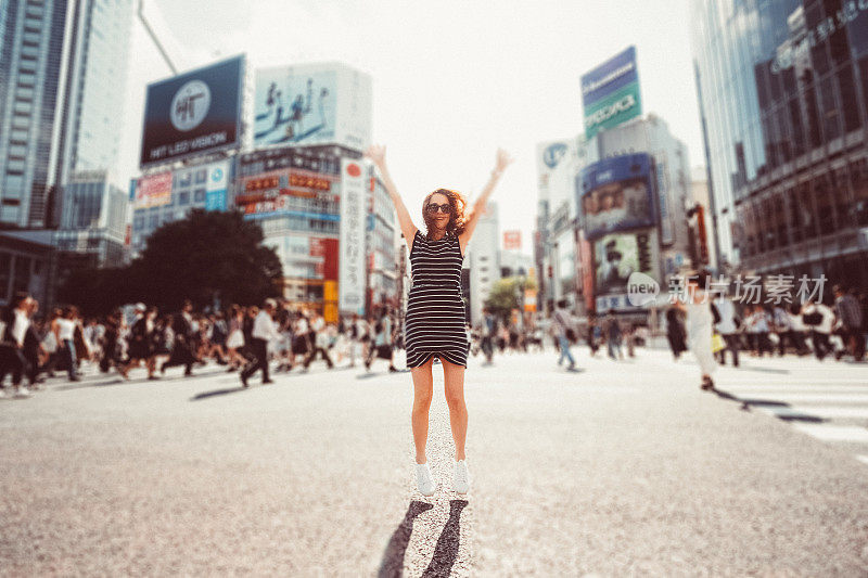 快乐的日本女游客从涩谷十字路口跳下