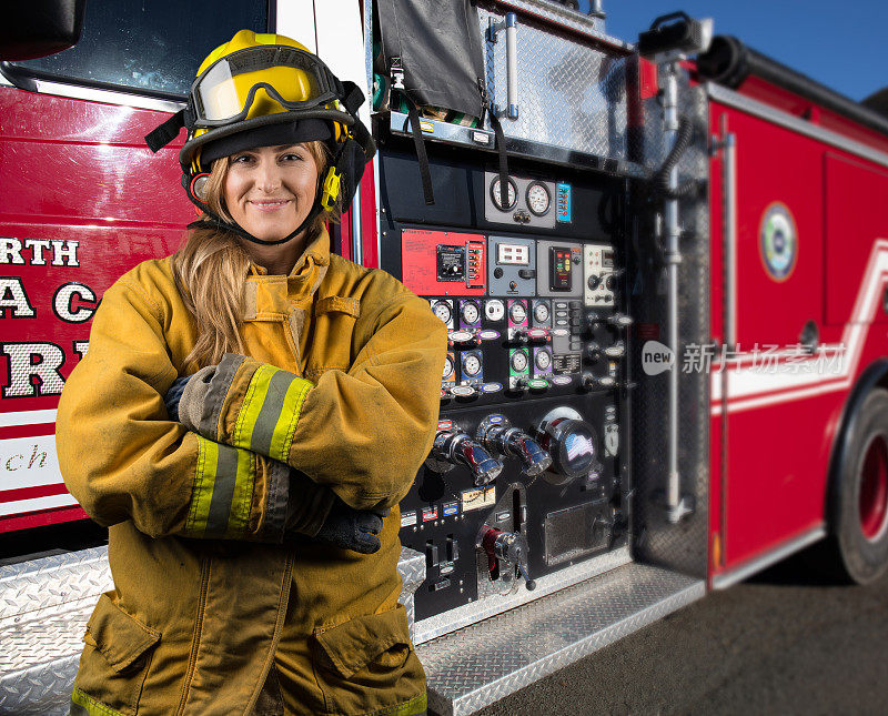 消防车旁的女消防员:加利福尼亚农村的一幅看着摄像机的肖像