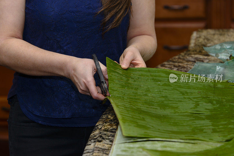 年轻女子正在切香蕉叶做玉米粉蒸肉