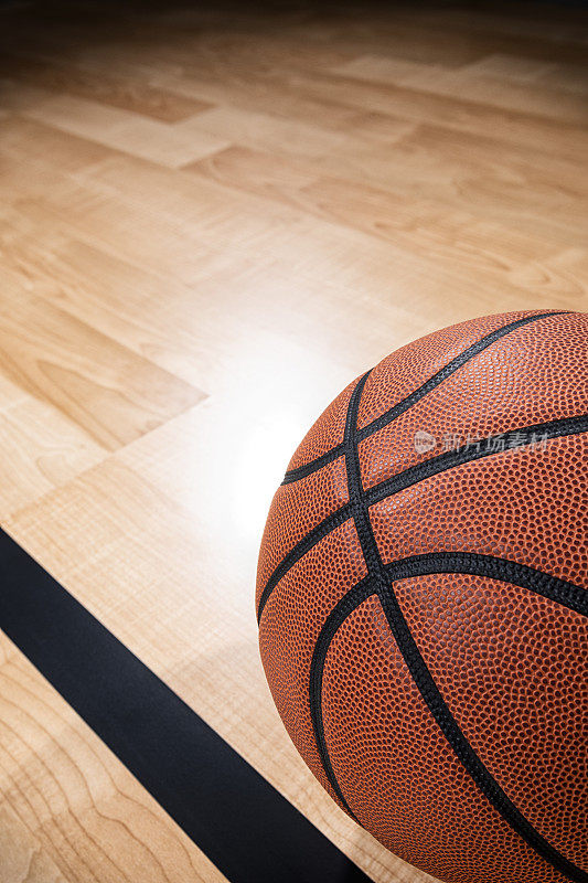 一个篮球和黑色的线与竞技场木地板的背景