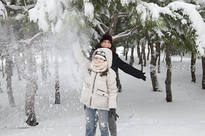 妈妈和女儿在雪中玩耍