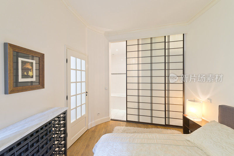 现代设计的卧室，浴室和衣柜被日式推拉门隔开。