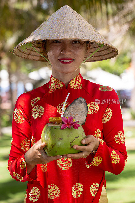 异国情调的传统越南女孩，同时提供新鲜的椰果和鲜花