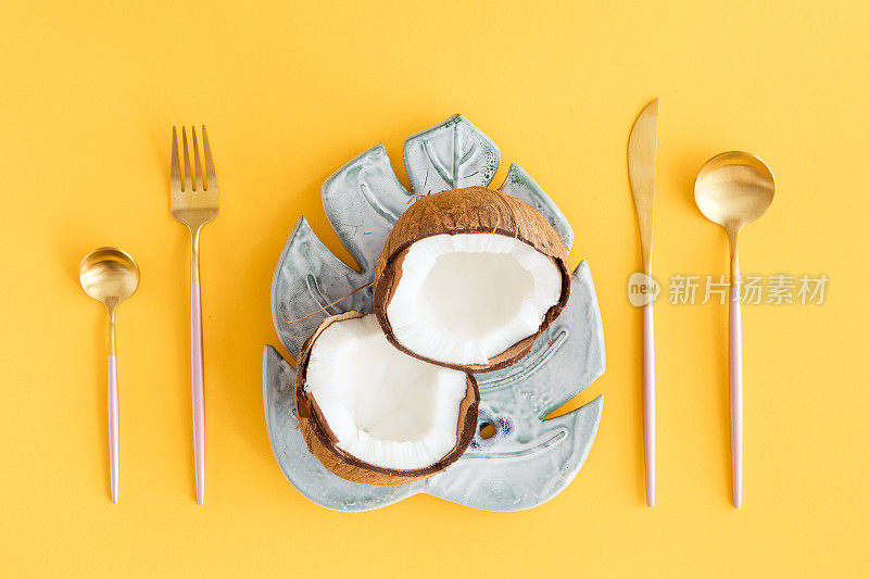 椰子叶盘，黄底餐具的创意布局。平的。