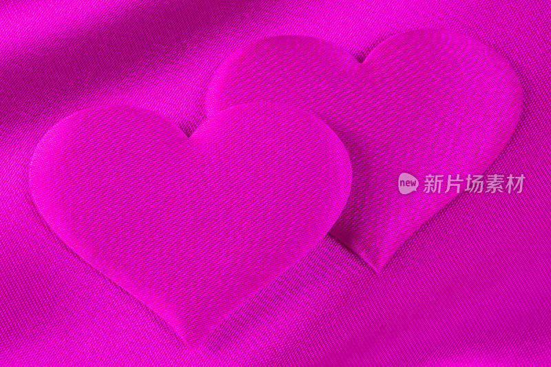 浪漫的背景――粉红缎子上的一对粉色心形