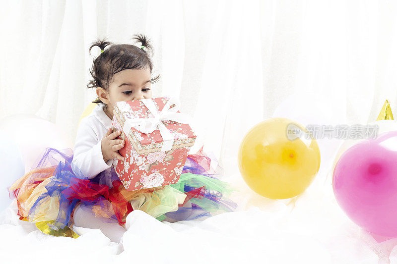 漂亮的小女孩在一周岁生日派对上拿着气球