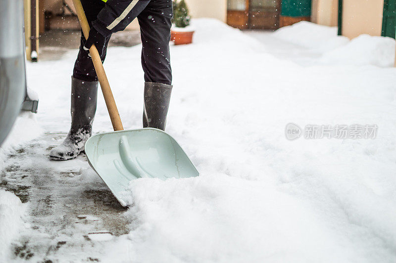 有人用雪铲清扫人行道