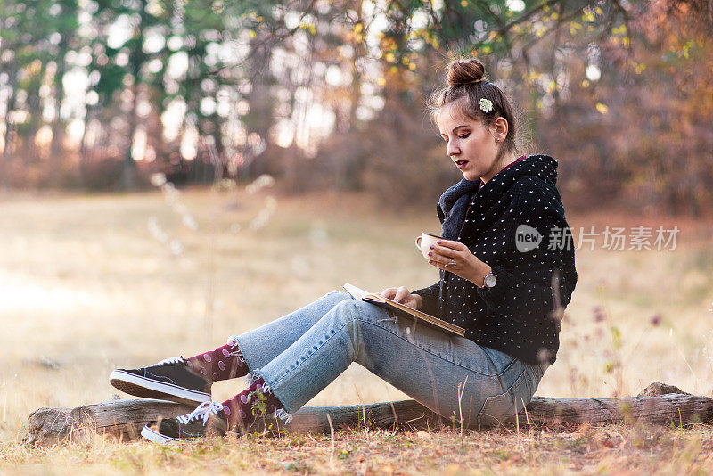 一个在户外看书喝咖啡的女人