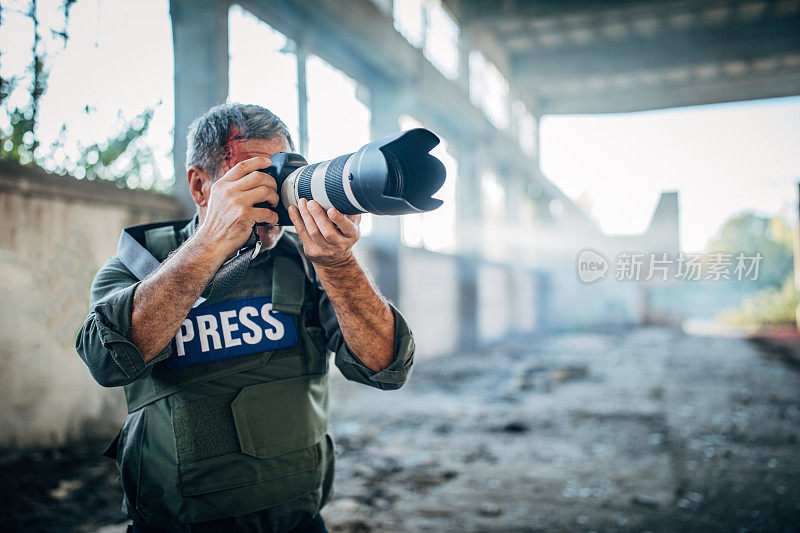 受伤的战地记者带着相机在废弃的建筑里