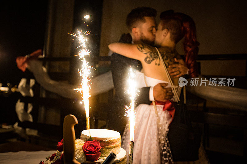 夫妻在婚礼蛋糕旁接吻