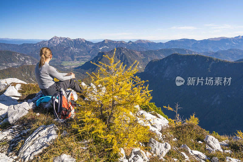 妇女享受美丽的景色从山顶Macesnovec在朱利安阿尔卑斯，斯洛文尼亚