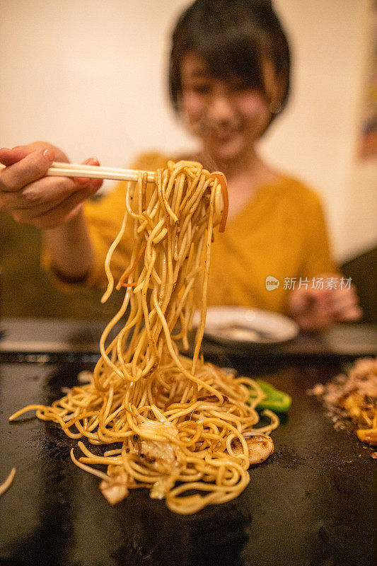 一个年轻女子在日本餐馆买日式烤饼