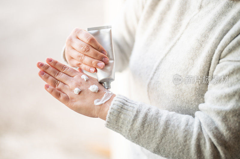 女人用护手霜在手上画笑脸