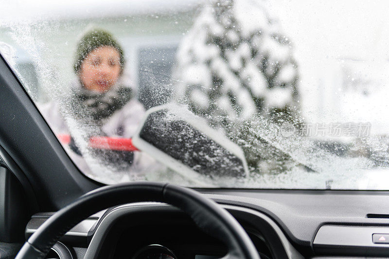 多民族家庭在暴风雪后清除汽车上的积雪