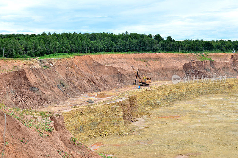 巨大的挖掘机与电铲在采石场工作。大型自卸卡车在石灰石露天开采中运输矿物。白俄罗斯，维捷布斯克地区最大的白云岩露天矿