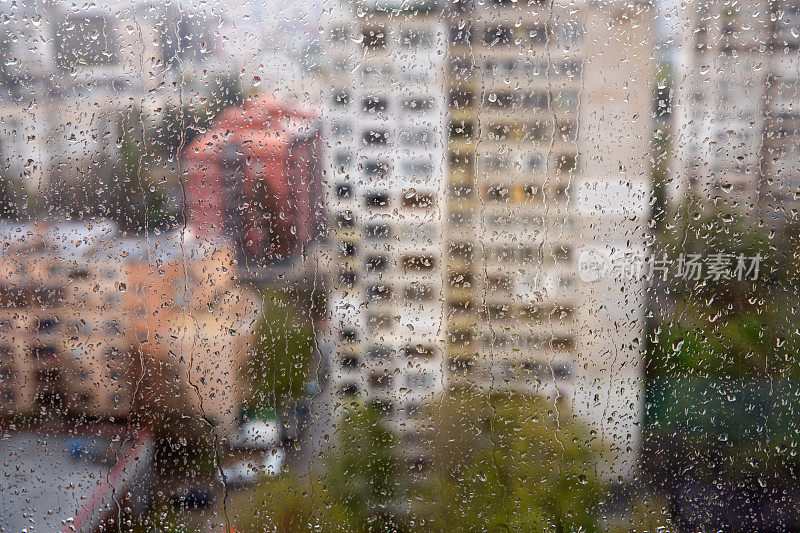 雨天的城市透过窗户看到被闪亮的雨滴覆盖