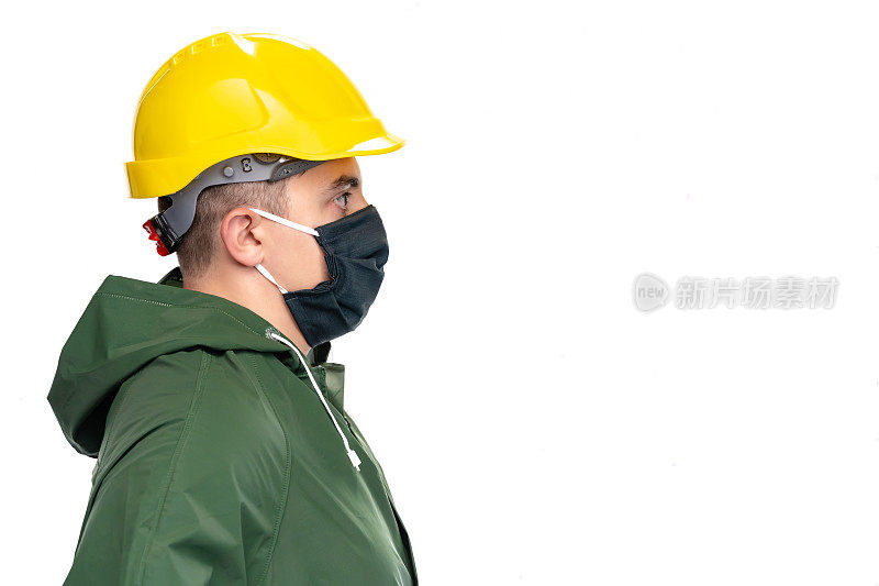 年轻的男性工程师，工人或建筑师的侧面与保护面罩看在白色背景上的相机