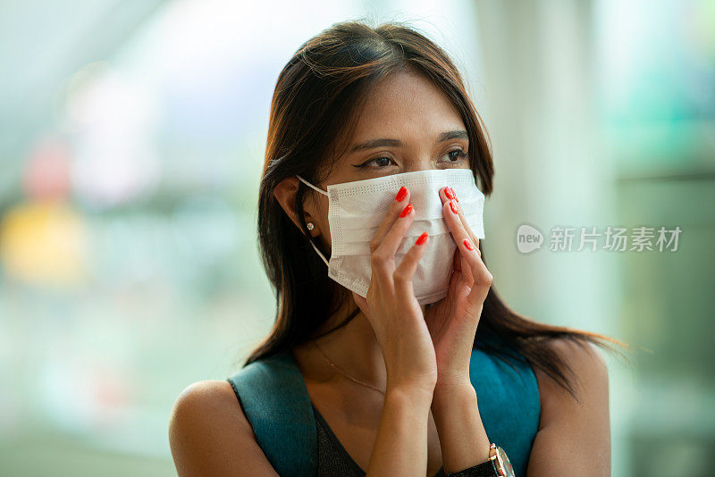 生活在过敏。概念、疾病、病毒、过敏、空气污染。年轻的亚洲女子走在城市里用手指压着防护面具