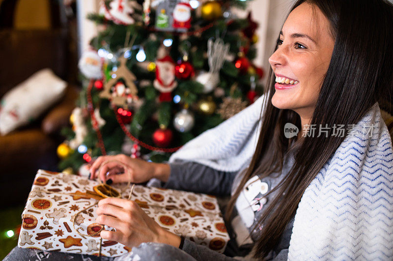 一个漂亮的女人微笑着拆圣诞礼物