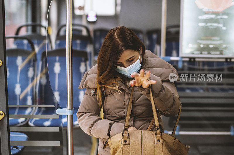 车上一个年轻的白人女人戴着防护面罩