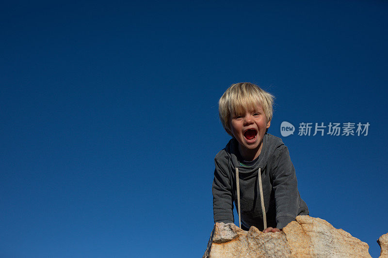 一个小男孩在南非塞德堡山的岩石上玩耍