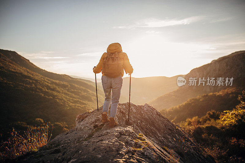 年轻女子背着背包在山里徒步旅行