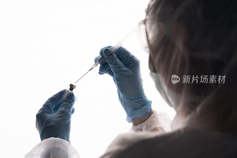 女医生正在挂疫苗和注射器