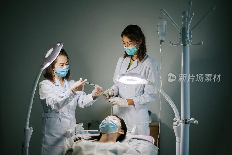 两名华裔女护士在手术室准备注射疫苗的注射器