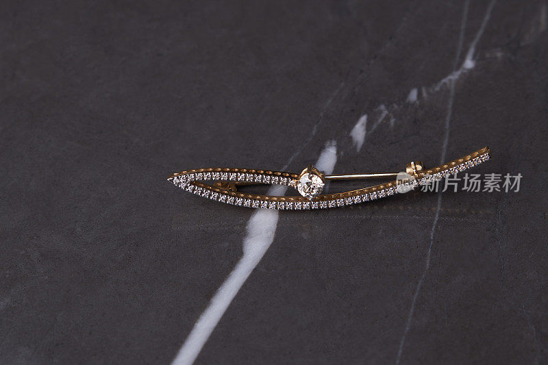 粉彩丝绸背景上的钻石胸针，特写。