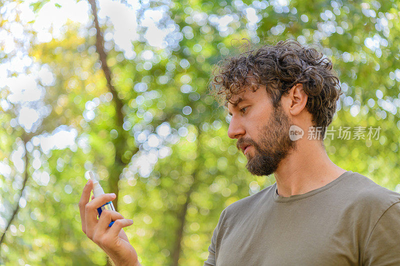 年轻英俊的男人在外面的大自然中有鼻窦炎的问题。