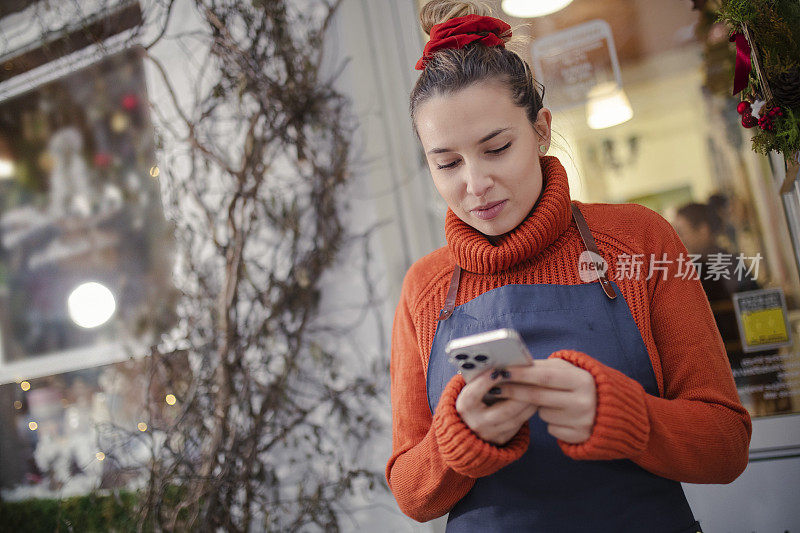 店老板在外面用手机或平板电脑查看监控录像