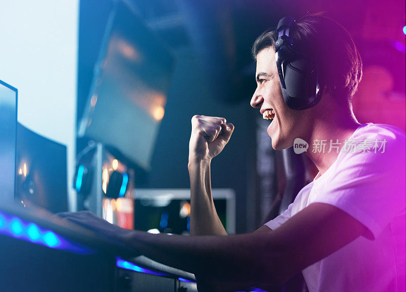 一个年轻人在玩电脑游戏时欢呼的镜头