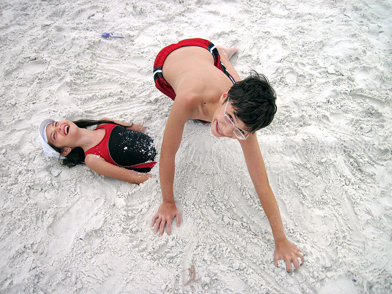 靠近两个在热带沙滩上玩耍的孩子