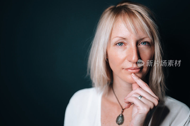 特写一个美丽的年轻女子思考或有一个想法孤立在黑暗的背景