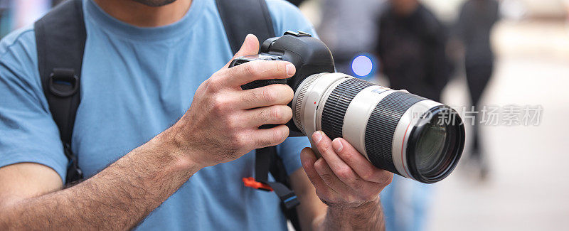 摄影师在城市里用数码单反相机拍照。