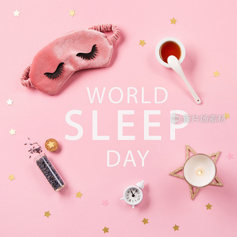 3月是世界睡眠日。可爱的睡眠面具和闹钟粉红色粉彩背景，俯视图。