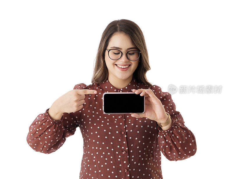 快乐的年轻女子显示屏幕的手机和指向