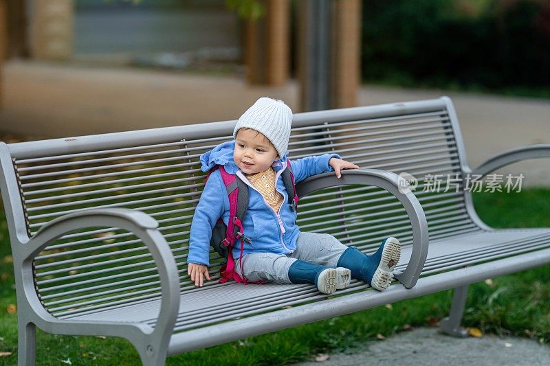 放学后，一个小女孩在外面的长椅上等着