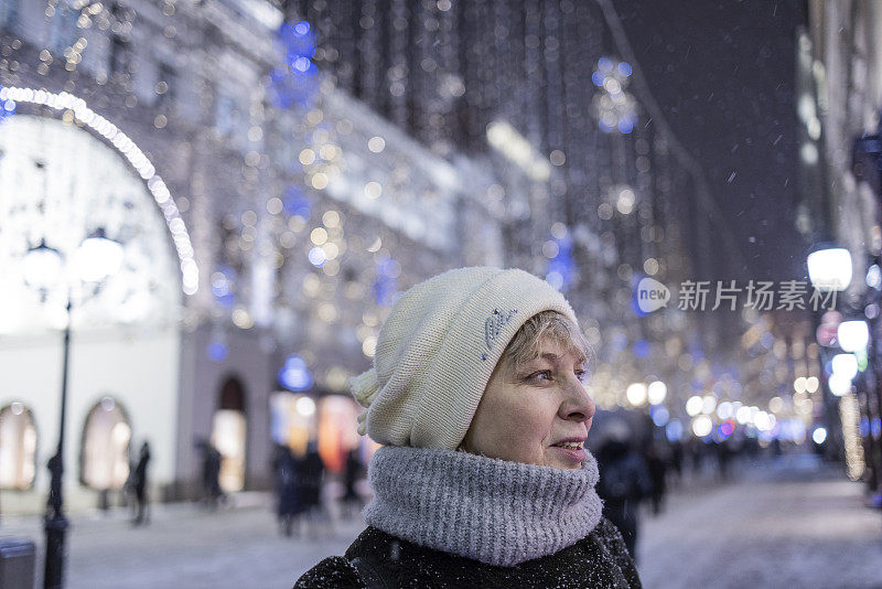 在圣诞节期间，游客们在为节日装饰的大城市里享受灯火通明的街道。