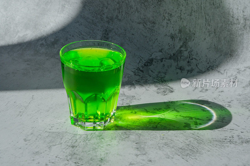阳光在绿色饮料里。夏天清爽的碳酸柠檬水在一杯。碳酸龙蒿饮料。