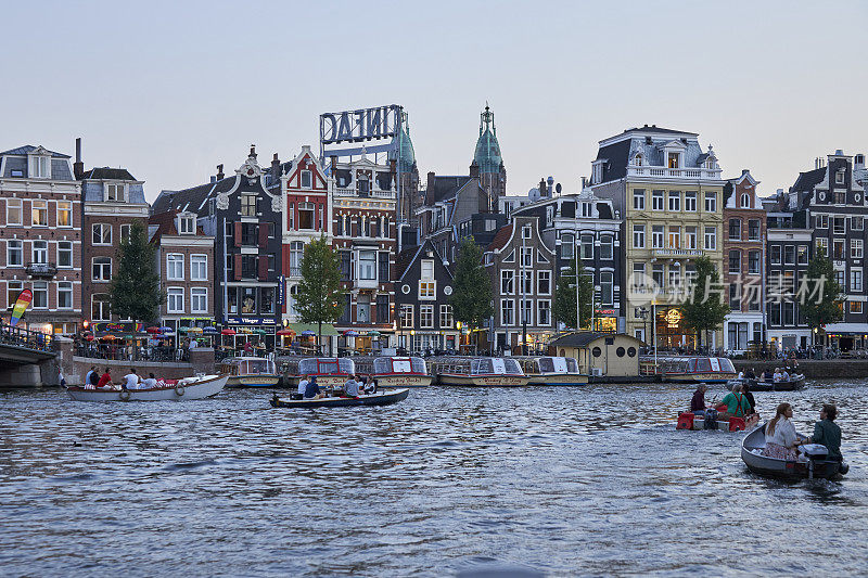 黄昏时分，阿姆斯特丹的阿姆斯特尔河上有休闲摩托艇